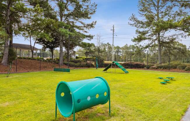 a park with a green playground and a swing set