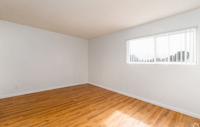 Empty room with wooden floor and white walls.