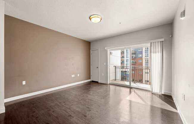 a bedroom with hardwood flooring and a balcony