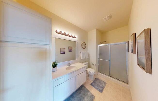 A bathroom with a white sink and a white toilet.