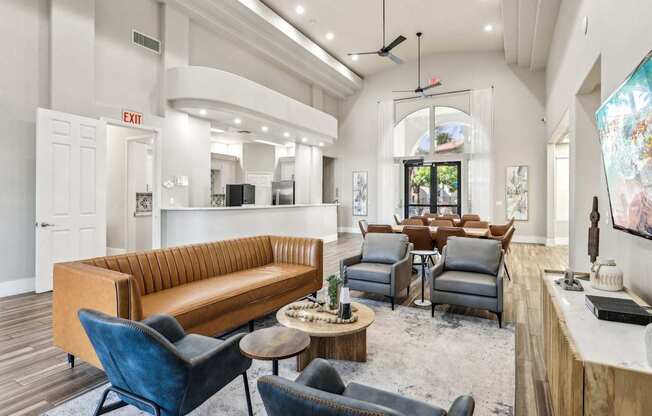 A living room with a brown couch, blue chairs, and a wooden coffee table.