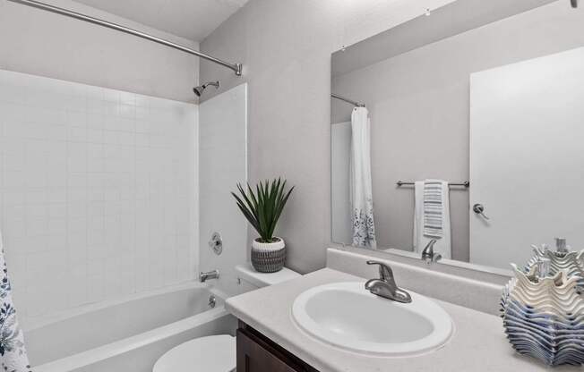A bathroom with a white sink and a white toilet.