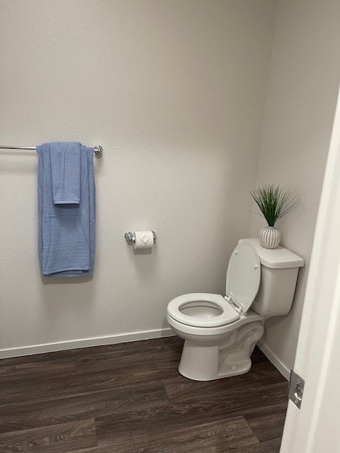 a bathroom with a white toilet and a blue towel