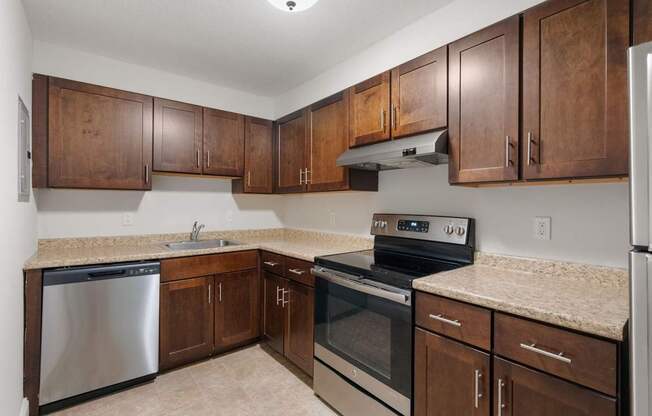A kitchen with wooden cabinets and stainless steel appliances.