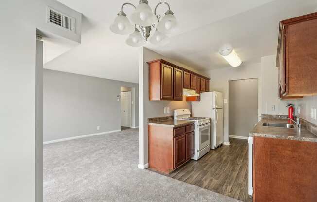 a kitchen with white appliances and wood flooring in a new home