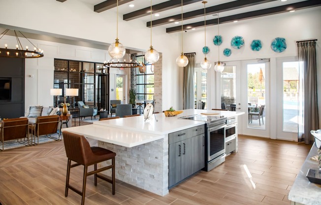The Alexandria communal kitchen with bar-style seating and wood-designed flooring in Madison, AL