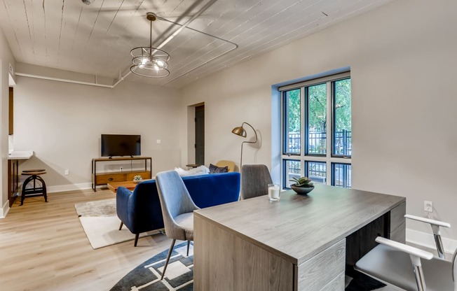 a living room with a couch and a desk with a table and chairs