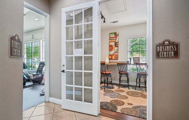 A white door with a glass panel is open to a room with a brown rug on the floor.
