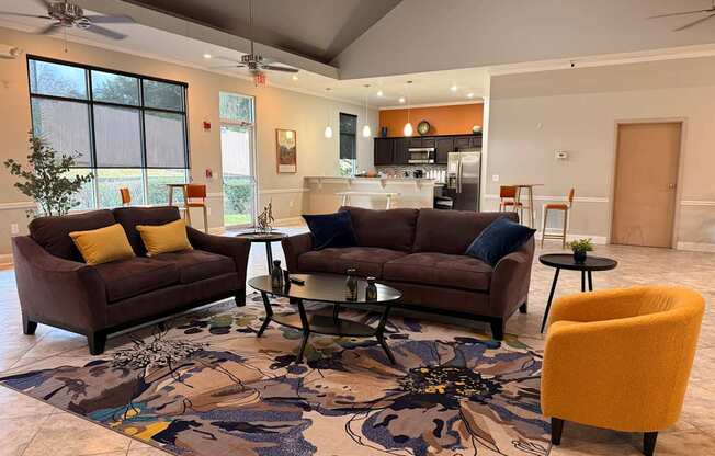 A living room with a brown couch, a yellow chair, and a patterned rug.