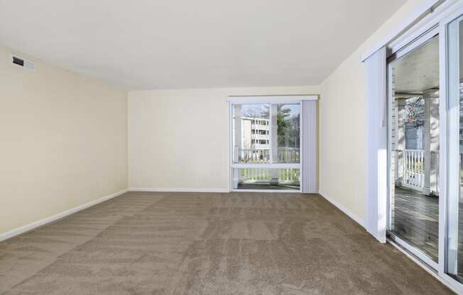 a living room with carpet and sliding glass doors to a balcony