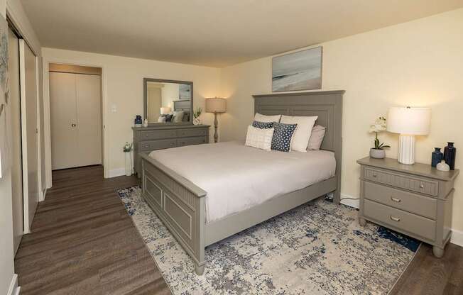 A bedroom with a bed, dresser, and nightstand.