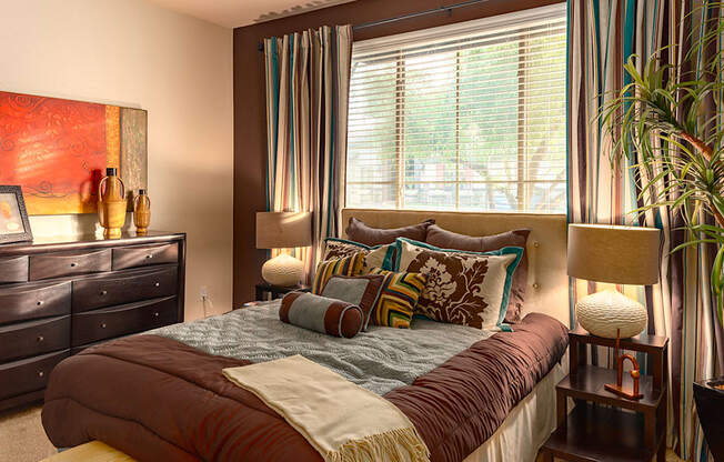 a bedroom with a large bed in front of a large window