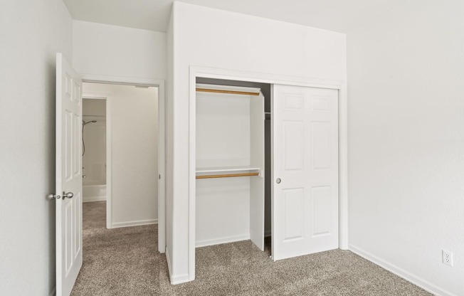 a bedroom with white walls and a carpeted floor