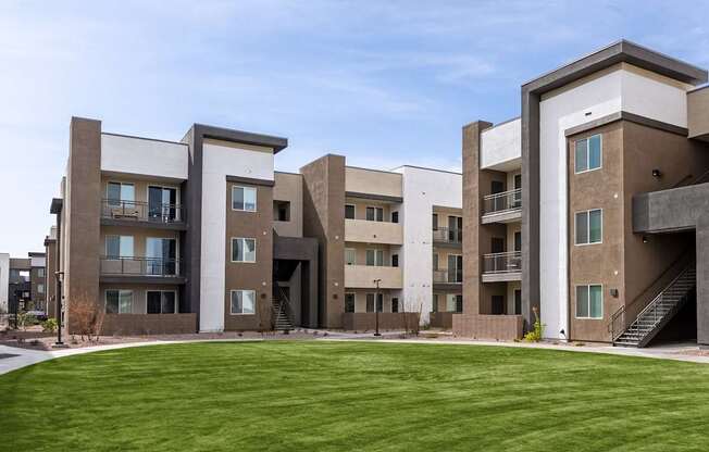 Apartment complex with a green lawn in front.