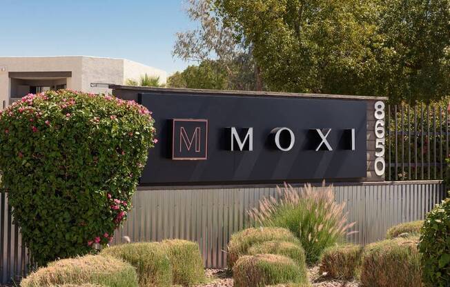 A sign that says Moxi in front of a building.