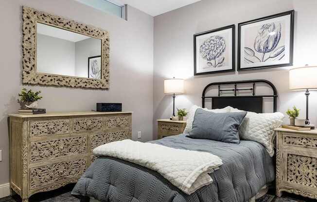 A bedroom with a bed, nightstands, and a mirror.