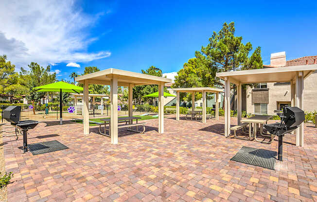A patio with tables and chairs under umbrellas.