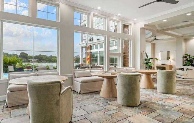 A spacious living room with a large window overlooking a tree-filled landscape.