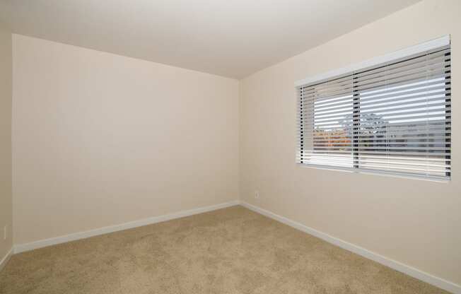 The One Bedroom Home bedroom with a window and a carpeted floor at Rocklin Manor  Apartments, Rocklin  