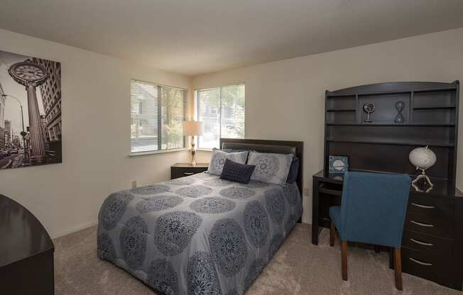A bedroom with a bed, desk, and chair at Bishop's Court Apartments, California, 95670