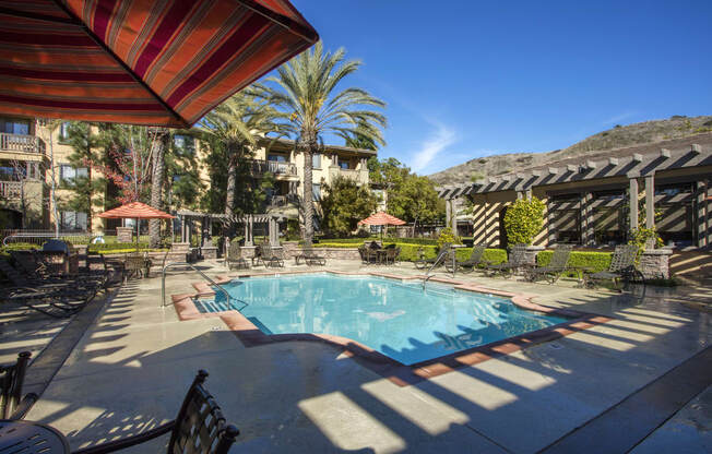Apartments for Rent in Ladera Ranch, CA-55+ Remington at Ladera Ranch-Pool with Lounge Seating, Umbrellas, and Tables