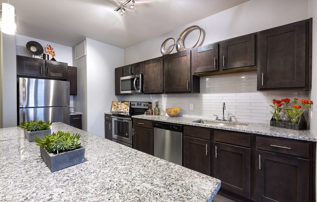 a kitchen with stainless steel appliances and granite counter tops at North Creek, Hutto