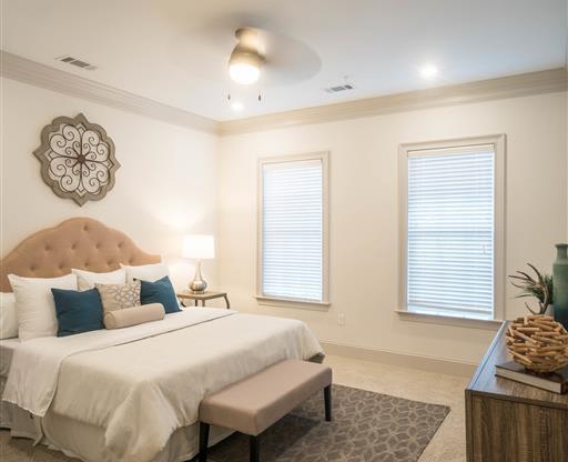 A serene bedroom with a tufted headboard, side tables, and soft lighting.