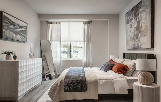A bedroom with a large bed and a painting on the wall.
