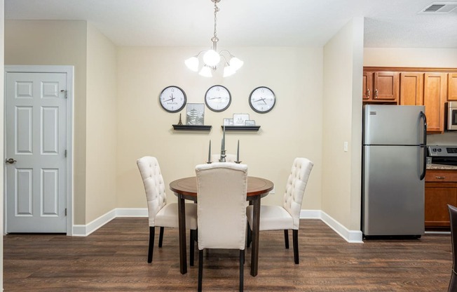 a dining room with a table and chairs and a refrigerator