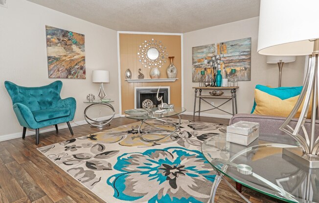 A living room with a fireplace and an area rug at The Drake in Bossier City, LA