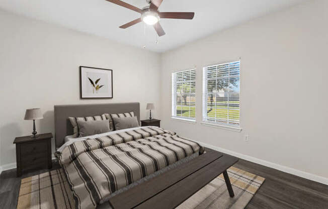 A bedroom with a bed, nightstand, and a ceiling fan.