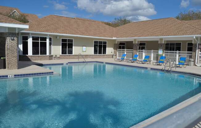 a large swimming pool in front of a building with a resort style pool