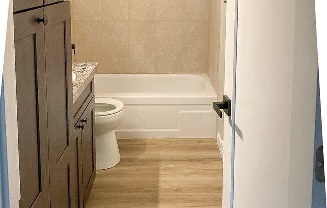 A small bathroom with a toilet, sink and bathtub.