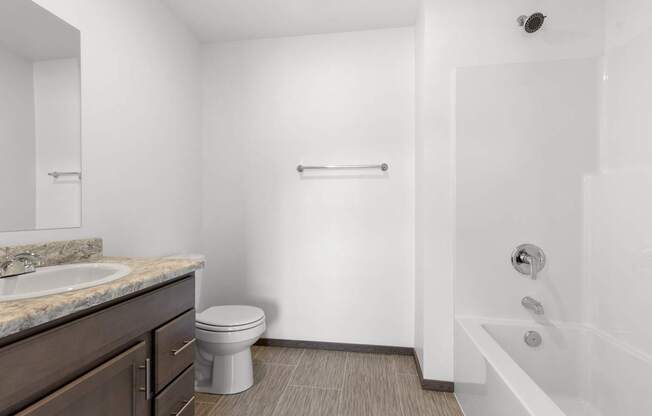 A white bathroom with a toilet, sink, and bathtub.