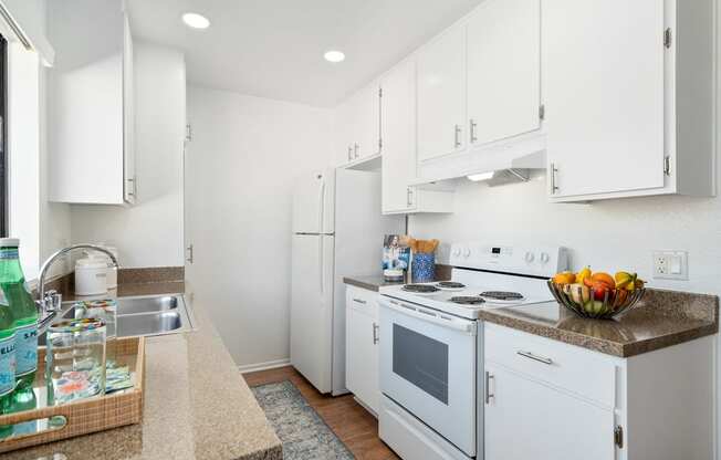 a white kitchen with white appliances and white cabinets