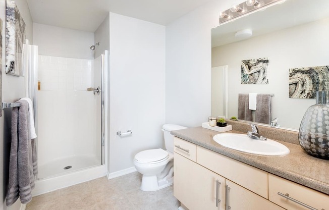 A bathroom with a toilet, sink, and mirror. at La Jolla Crossroads Apartments, San Diego, CA, 92122