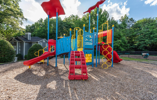 a playground with a swing set and slides at a park