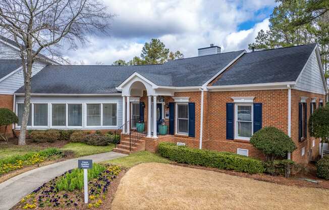 a brick house with a front yard and a sidewalk