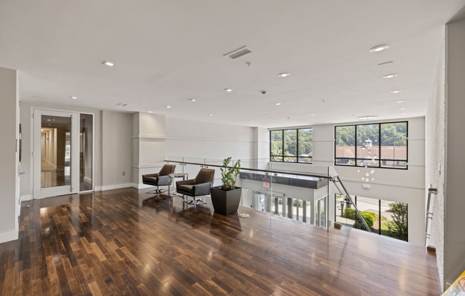 a large living room with hardwood floors and white walls