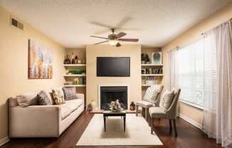 a living room with a ceiling fan and a television