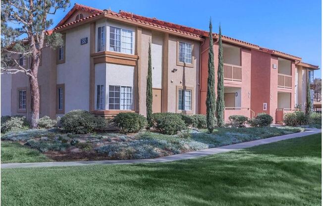 an apartment building with a sidewalk in front of it at Riverview Springs, Oceanside, CA