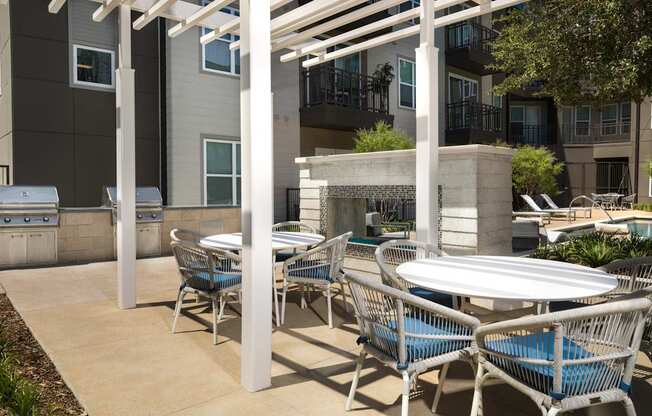 a patio with tables and chairs and a fire place