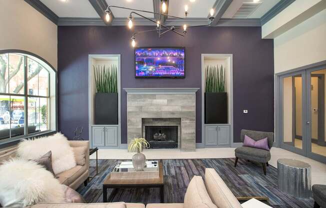 A living room with a fireplace and a flat screen TV mounted above it.