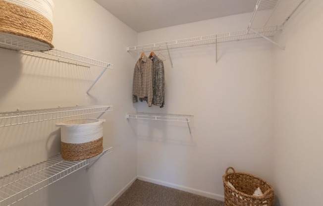 This is a photo of the primary bedroom walk-in closet of the 890 square foot 2 bedroom, 2 bath Liberty at Washington Place Apartments in in Miamisburg, Ohio in Washington Township.