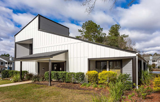 A modern house with a white exterior and a grey roof.