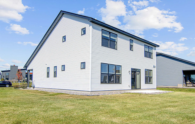 a white house with a black roof and white siding