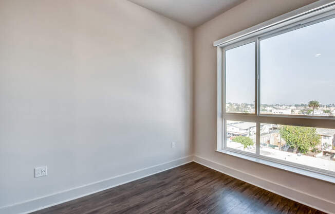 A room with a large window and wooden flooring.