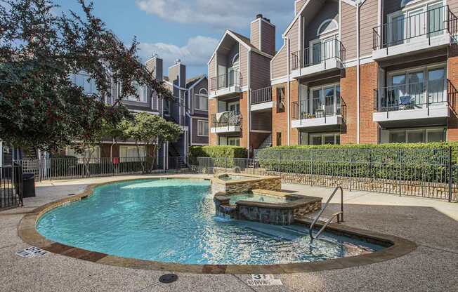 A swimming pool in front of apartment buildings.