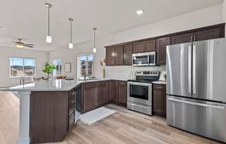a kitchen with stainless steel appliances and wooden cabinets at The Residences Apartments at Bear Tree | DeForest, WI, DeForest, 53532