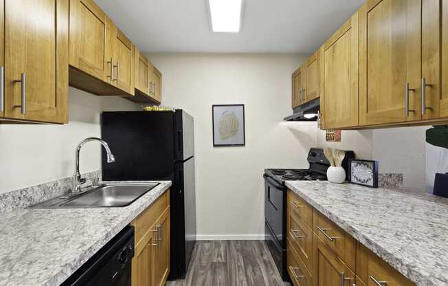 Spacious Kitchen with Plank Flooring, Overhead Lighting, and Light Brown Cabinetry at Pacific Park Apartment Homes, Edmonds, 98026